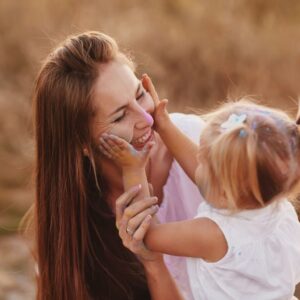 äiti pitää lasta sylissään ja hymyilee onnellisena - Sydänvoimaa äitiyteen -tunnetaitokurssi